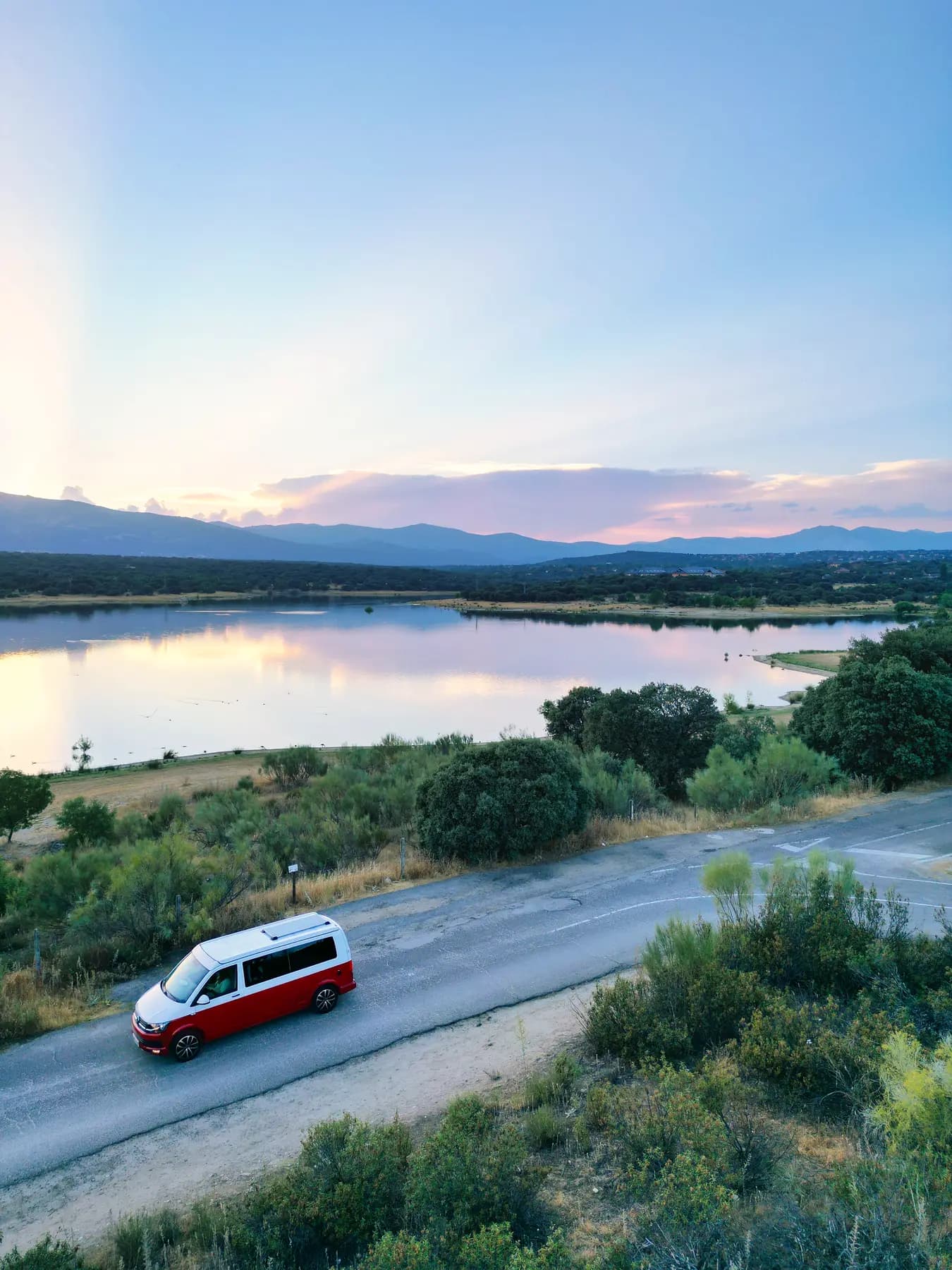 Camper VW de beWinkle aparcada junto a un embalse de la Sierra de Madrid al atardecer