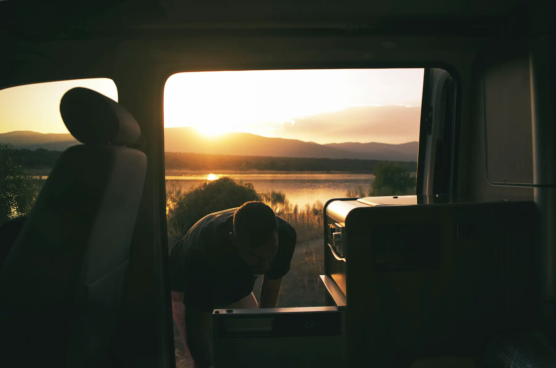 Atardecer desde la puerta de una camper beWinkle junto a un embalse, el momento perfecto para pernoctar legal
